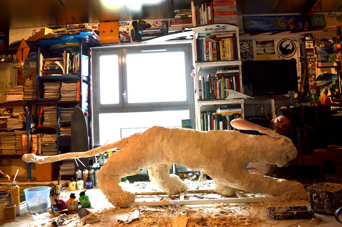 Sculpture de félin allongée sur une table de l’atelier
